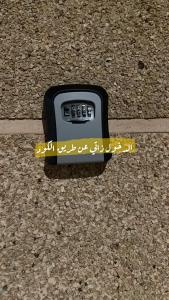 a remote control sitting on the ground next to a cell phone at شقة فندقية غرفتين نوم وغرفة معيشة ومدخل خاص وباركنج سيارة in Riyadh Al Khabra