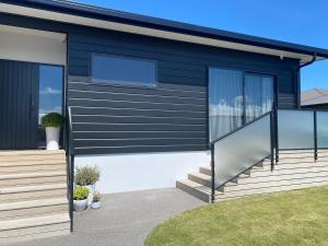 a house with black siding and glass windows at Views on Victory in Taupo
