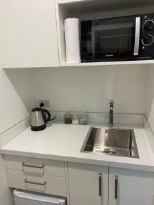a kitchen with a sink and a microwave at Views on Victory in Taupo
