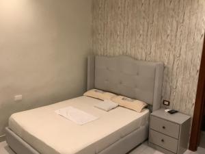 a small bedroom with a bed and a nightstand at Hotel Blue Malecón And Spa in Santo Domingo