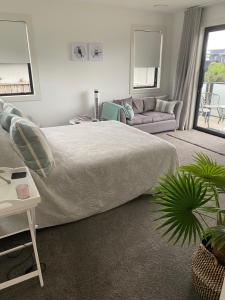 1 dormitorio con 1 cama grande y 1 sofá en Views on Victory en Taupo
