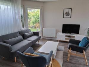 a living room with a couch and chairs and a tv at Cottage in Plouarzel in Plouarzel