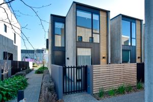 a house with a black door and a fence at Worcester Terrace Eleven - Christchurch Holiday Homes in Christchurch