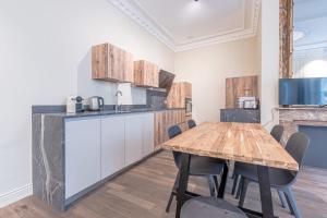 Il comprend une cuisine et une salle à manger avec une table et des chaises en bois. dans l'établissement La Cour Dorée, à Metz