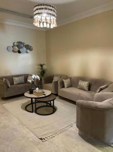 a living room with two couches and a table at شقة فندقية غرفتين نوم وغرفة معيشة ومدخل خاص وباركنج سيارة in Riyadh Al Khabra
