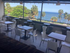 Hotel Blue Malecón And Spa في سانتو دومينغو: مطعم به طاولات وكراسي ومطل على المحيط