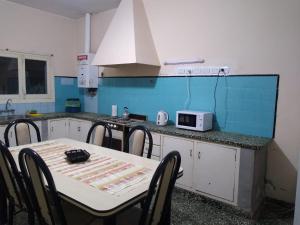 cocina con mesa con sillas y microondas en Casa céntrica El Rosal (cabaña) en San Rafael