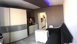 a living room with a black couch and a kitchen at Meri apartment in Rača