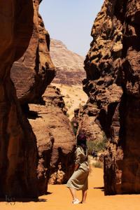 a woman walking through a canyon in the desert at golden day in Wadi Rum