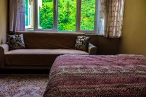 a living room with a couch and two windows at شقة أوزنجول 3 in Çaykara
