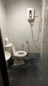 een badkamer met toilet en douche in een hokje bij Hotel Checkedinn in Ipoh