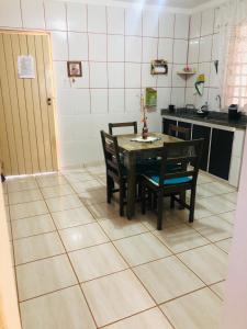 a kitchen with a table and chairs on a tiled floor at Recanto CharaBerbel in Salto de Pirapora