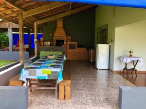 a room with a table and a kitchen with a refrigerator at Recanto CharaBerbel in Salto de Pirapora