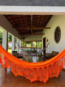 an orange hammock in the lobby of a house at Recanto CharaBerbel in Salto de Pirapora