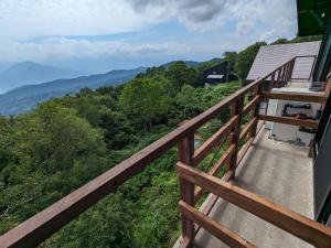 a balcony of a house with a view of the mountains at Aki's Apartments Madarao in Iiyama