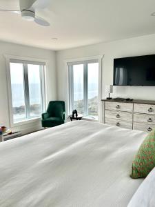 a bedroom with a large bed with a television and windows at The View suites and breakfast in Triton, Newfoundland in Pilleyʼs Island