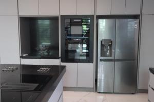 uma cozinha com frigorífico de aço inoxidável e bancada preta em Empire Villa Paramaribo Noord 1 em Paramaribo