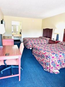 Una habitación de hotel con dos camas y un escritorio. en Ashley inn, en Crossett
