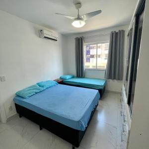 2 Betten in einem Zimmer mit Fenster in der Unterkunft Apt 3 Minutos Praia do Forte - Ar Condicionado in Cabo Frio
