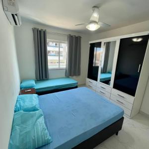 1 dormitorio con 1 cama y TV grande en Apt 3 Minutos Praia do Forte - Ar Condicionado, en Cabo Frío