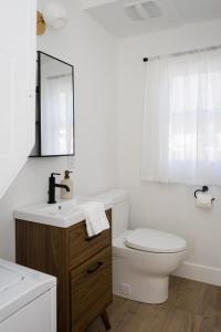 La salle de bains est pourvue de toilettes, d'un lavabo et d'un miroir. dans l'établissement The Darcie House - cozy, pet-friendly home in PEC, à Picton