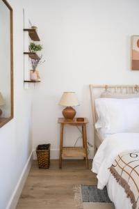 - une chambre avec un lit et une table avec une lampe dans l'établissement The Darcie House - cozy, pet-friendly home in PEC, à Picton