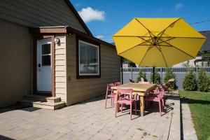 - une table et des chaises avec un parasol jaune sur la terrasse dans l'établissement The Darcie House - cozy, pet-friendly home in PEC, à Picton