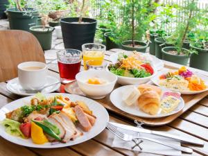 a wooden table topped with plates of food and drinks at APA Hotel Kochi in Kochi +16 photos