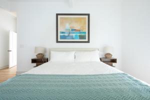 a bedroom with a white bed with a blue blanket at Modern retreat w/ stunning views & hot tub in Hoodsport