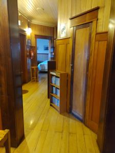 korytarz z pokojem z drzwiami i półką na książki w obiekcie Hostal Florencia w mieście Puerto Varas