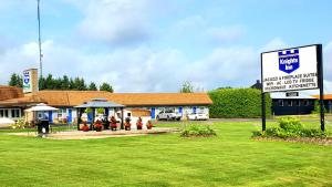 a group of people sitting in front of a building at Knights Inn Colonial Fireside Inn in Pembroke