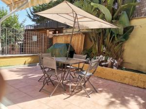 een tafel en stoelen met een parasol op een patio bij Dimora Shimbalaie in Bari