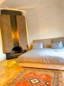 1 dormitorio con 1 cama y chimenea en Bienvenue à la Villa Luxe de 3 Suites pour Location Journée !, en Marrakech