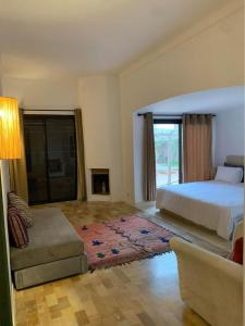 1 dormitorio con 1 cama y sala de estar con sofá en Bienvenue à la Villa Luxe de 3 Suites pour Location Journée !, en Marrakech