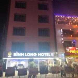 Bình Long II Hotel في Lai Châu: فندق فيه كراسي امام مبنى في الليل