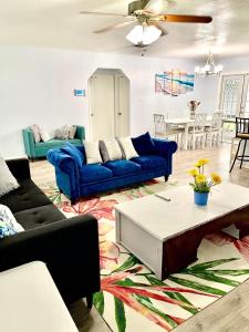 - un salon avec des canapés bleus et une table dans l'établissement A Cozy Space Coast Retreat, à Titusville