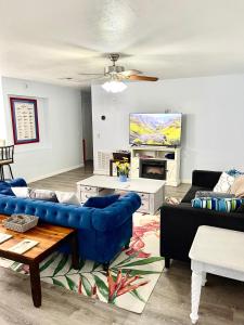 a living room with a blue couch and a tv at A Cozy Space Coast Retreat in Titusville