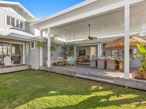 an outdoor patio with a deck with a table and chairs at Kia Orana Island Home with Pool in Casuarina