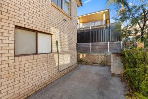 a brick house with a balcony on the side of it at Orana by Experience Jervis Bay in Vincentia