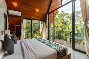 a bedroom with a bed and a large window at Modern 2 BR Villa Indra by Azure, in the Lap of Nature in Munggu