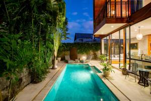 a swimming pool in a backyard with a house at Modern 2 BR Villa Indra by Azure, in the Lap of Nature in Munggu