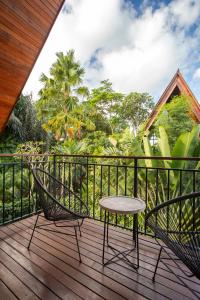 a patio with a table and chairs on a deck at Modern 2 BR Villa Indra by Azure, in the Lap of Nature in Munggu