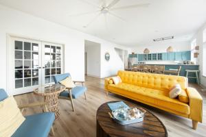 a living room with a yellow couch and a table at Modern retreat w/ stunning views & hot tub in Hoodsport