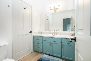 a bathroom with a blue cabinet and a sink at Modern retreat w/ stunning views & hot tub in Hoodsport +32 photos