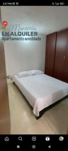 uma cama num quarto com uma placa na parede em Apto Conjunto Residencial Lima em Montería