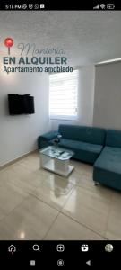 uma sala de estar com um sofá azul e uma mesa em Apto Conjunto Residencial Lima em Montería