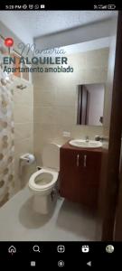 a bathroom with a toilet and a sink and a mirror at Apto Conjunto Residencial Lima in Montería