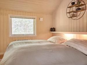 a bedroom with a bed and a window at Holiday home Nexø X in Vester Sømarken