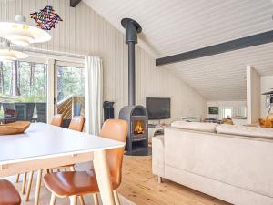 a living room with a table and a fireplace at Holiday home Nexø X in Vester Sømarken