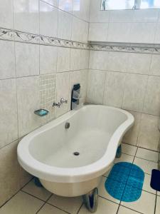 a white bath tub in a white tiled bathroom at Classic Holiday in New Germany